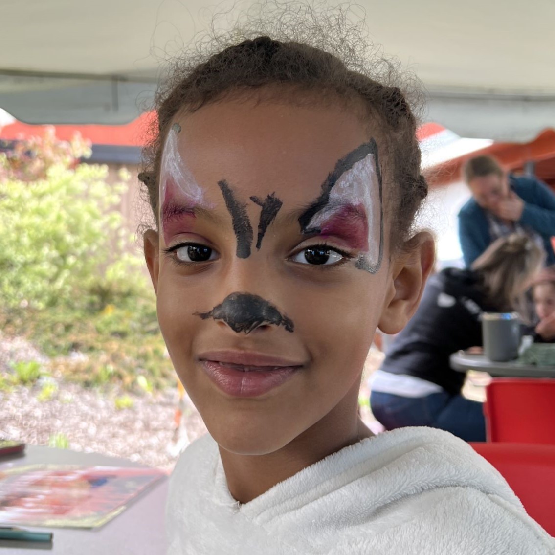 girl with painted face smiles