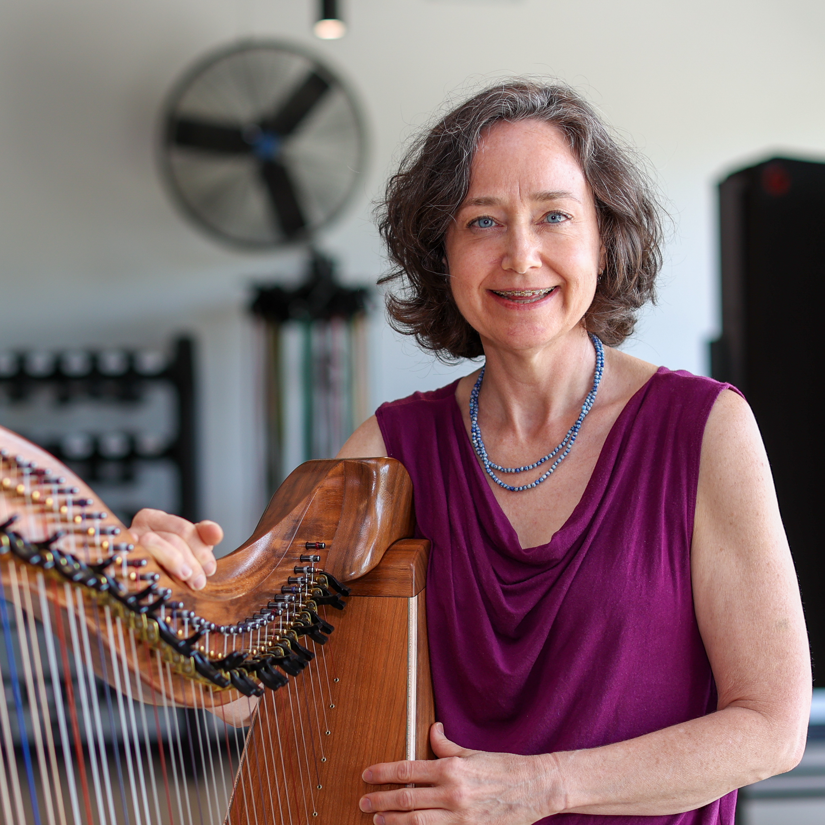 Justine Flynn smiling and posing with her harp