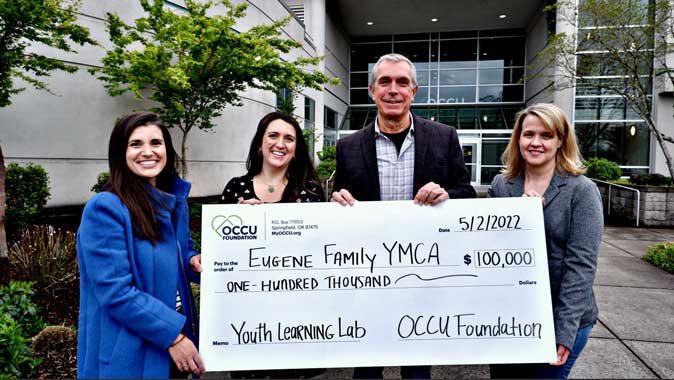 Eugene YMCA capital campagin volunteers and OCCU staff pose with large check