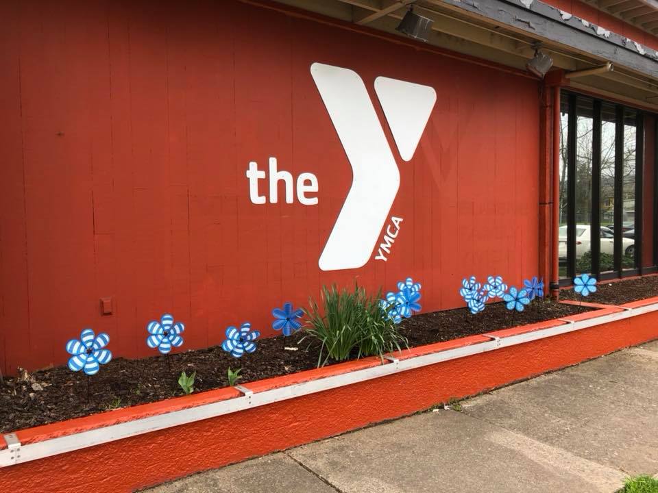 blue pinwheels for child abuse prevention month in front of the eugene ymca