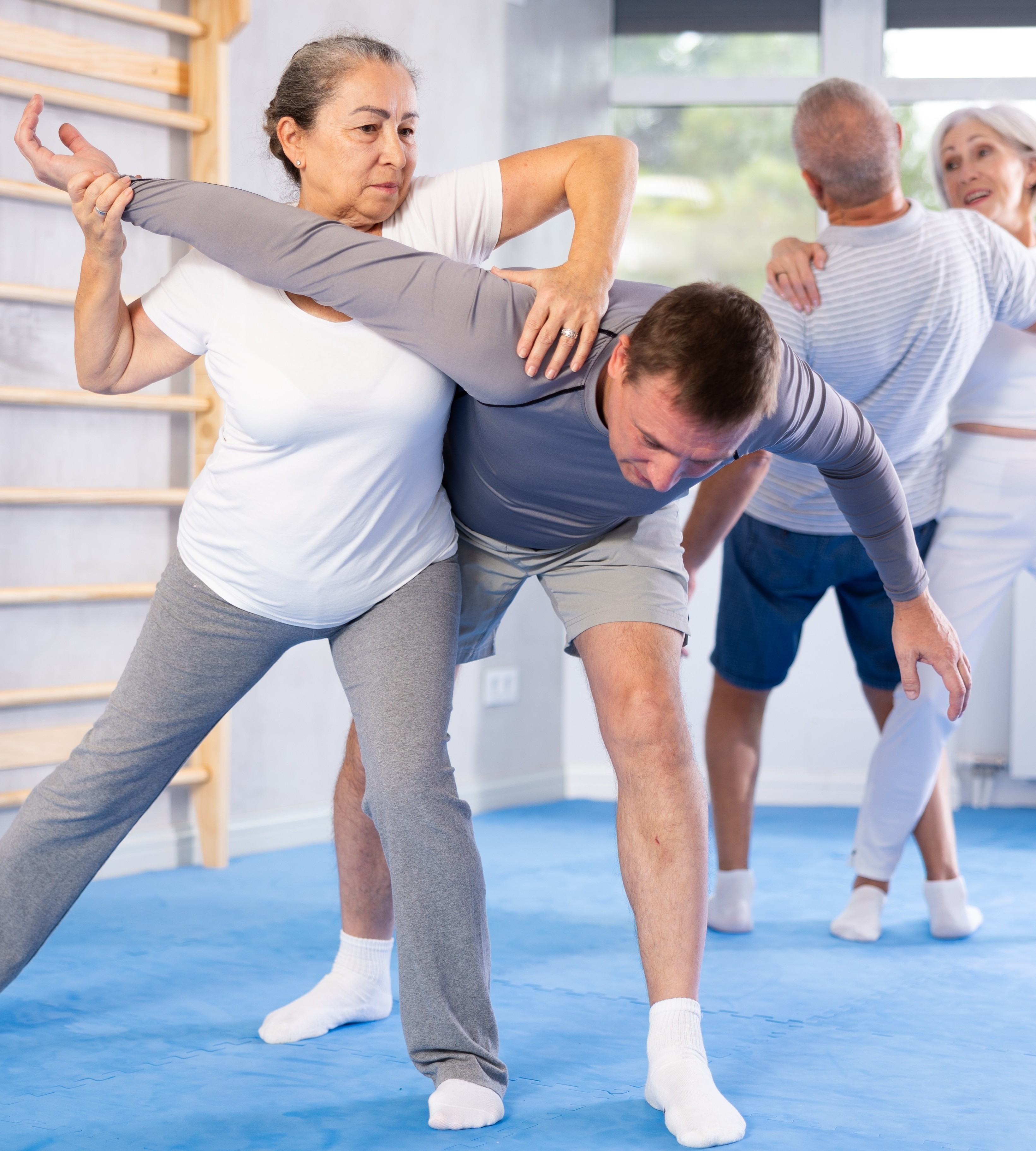 active older woman practices self-defense skills in a gym
