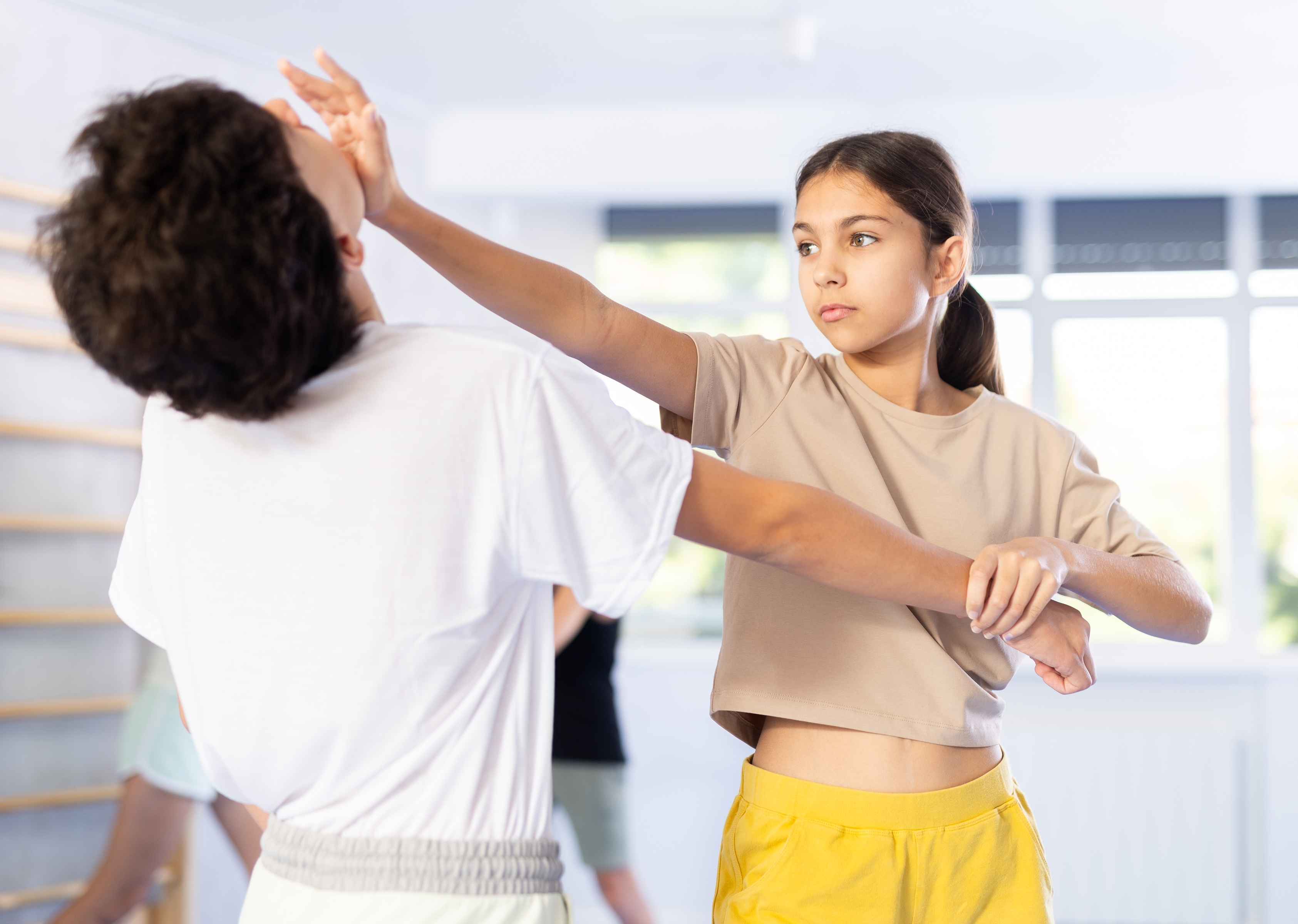 active older woman practices self-defense skills in a gym