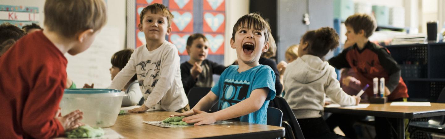 Early-learning children using clay in the classroom.