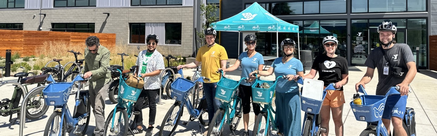 group of people going on a bike ride with peacehealth bikes in front of eugene family ymca 