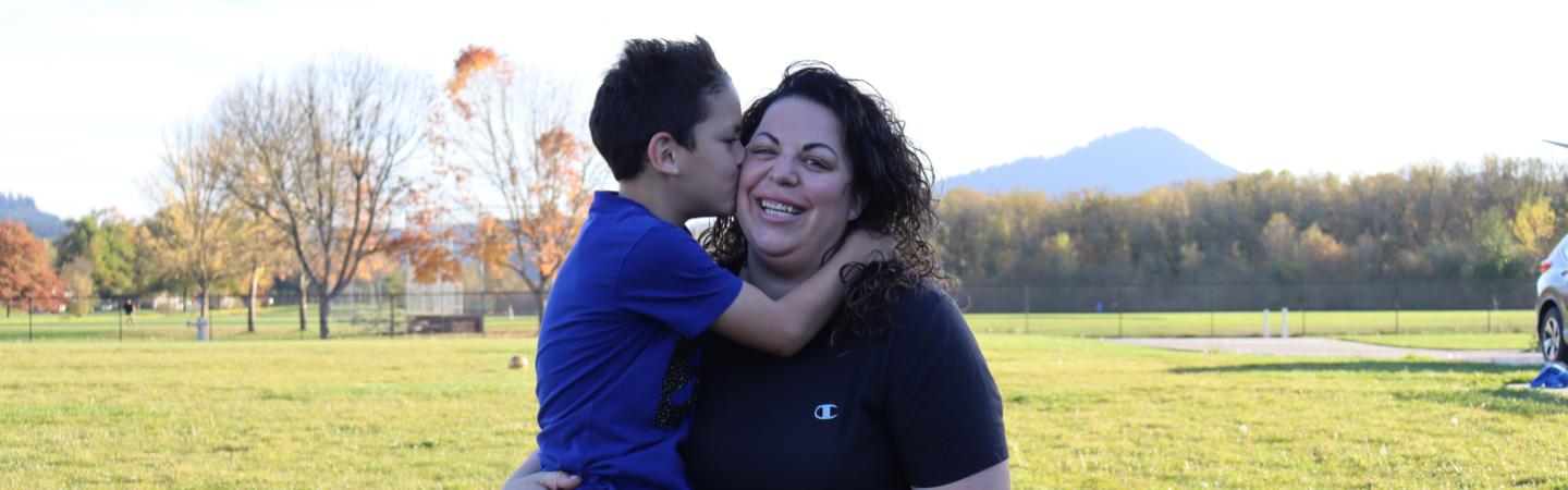 boy kisses mom on the cheek