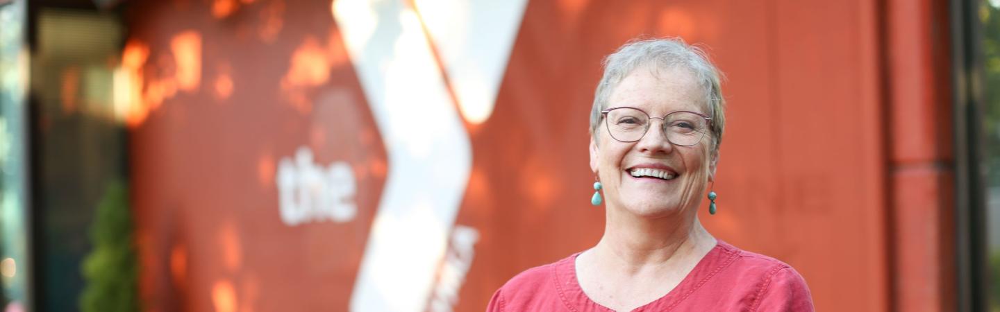diabetes prevention program participant, susan, smiles in front of eugene ymca facility