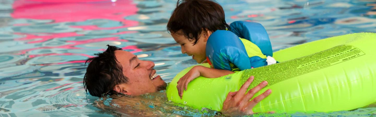 father and son swim in the ymca lap pool