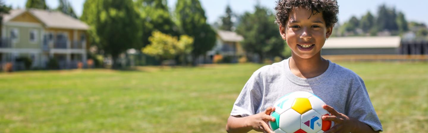 young boy plays ymca soccer game at summer camp