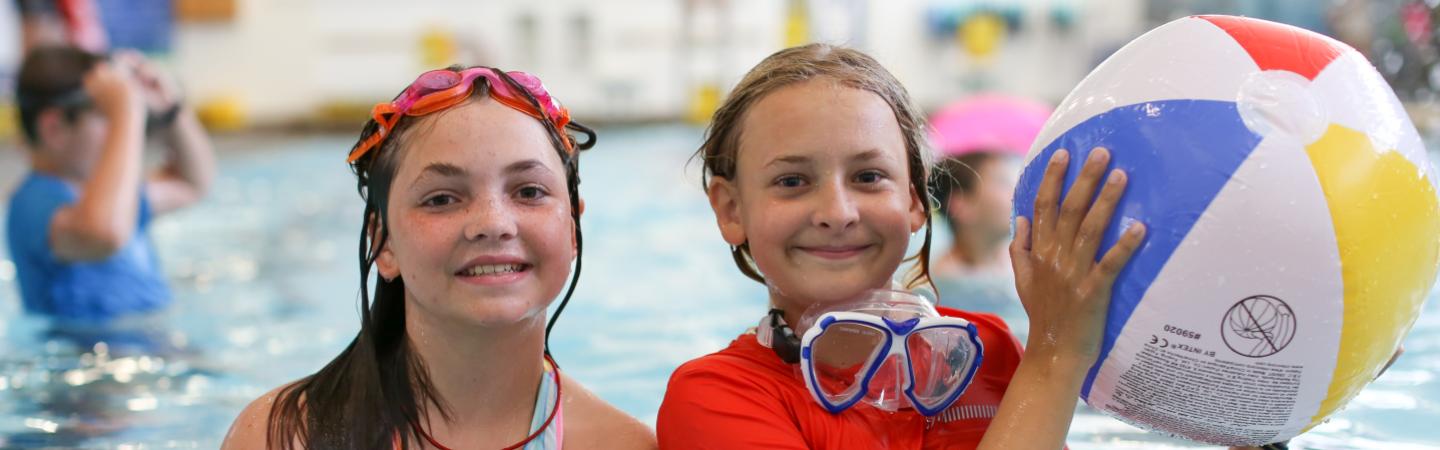 two girls swim in the ymca pool