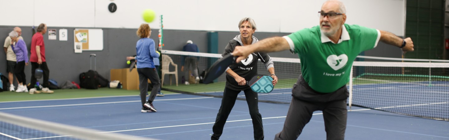 man and woman play pickleball at eugene ymca tennis and pickleball center