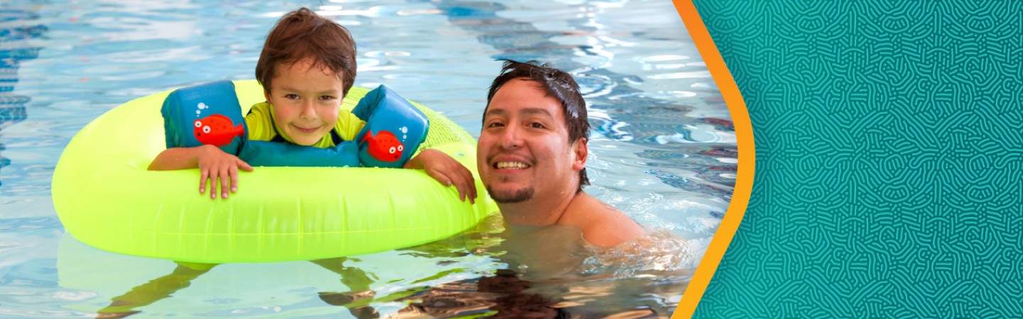 a father and son smiling and floating in the YMCA pool