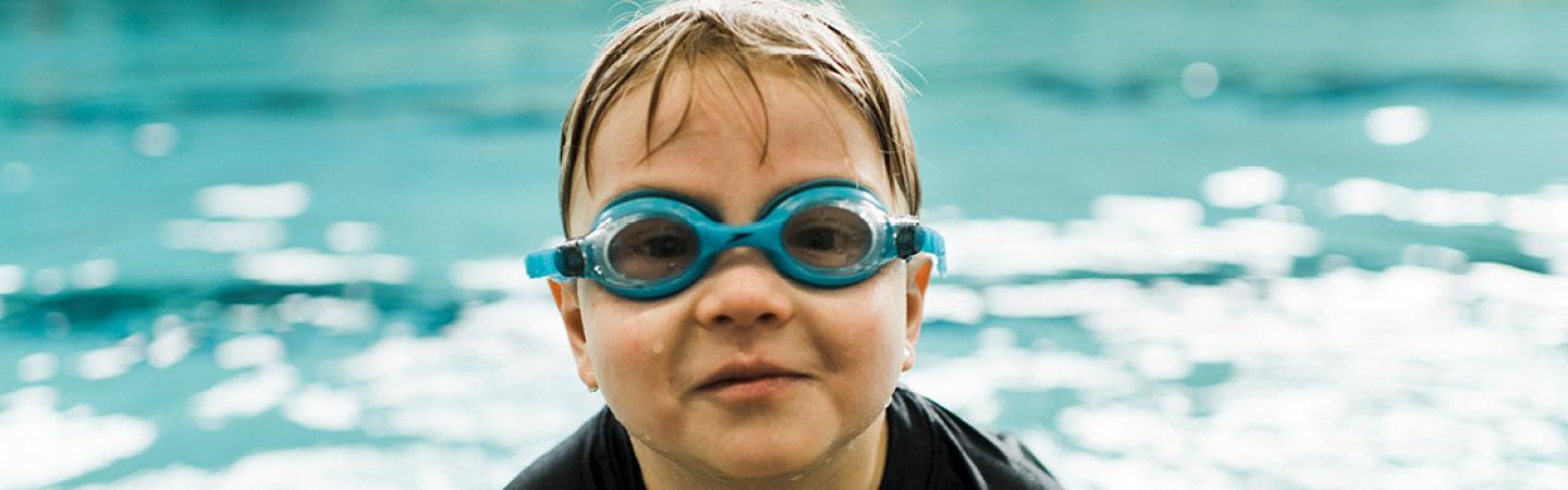 kid with goggles in pool