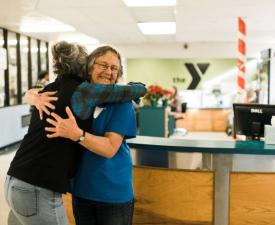 ymca members hug at the welcome center