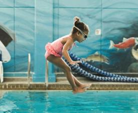swim lessons participant jumps into ymca pool