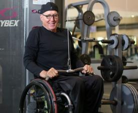 man in wheelchair uses strength equipment