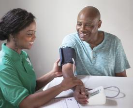 ymca staff takes man blood pressure for blood pressure self monitoring program