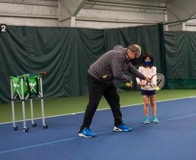 teaching tennis to child player