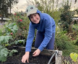 boy plays in garden at eugene ymca afterschool care