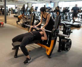 girls lift weights using barbell press in work out room