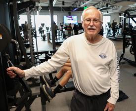senior man lifts weights in the ymca gym