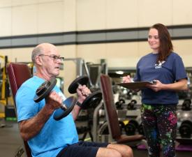 eugene ymca member doing bicep curls next to instructor