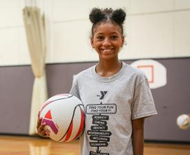 young girl plays basketball during eugene ymca sports camp