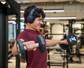 teenage boy lifts weights in ymca gym