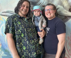 two parents and their baby posing in YMCA Aquatics Center