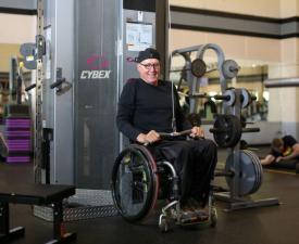 man in wheel chair uses exercise equipment at eugene ymca